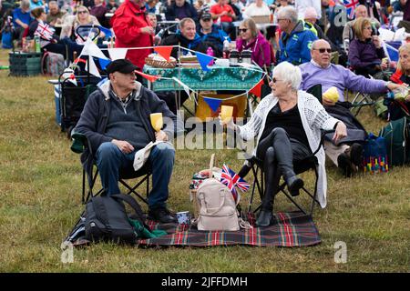 Woodstock, Oxfordshire, Großbritannien. Juli 2022. Ein Paar mit Drinks und Union Jack. Battle Prom Picknickkonzerte. Schloss Blenheim. Vereinigtes Königreich. Quelle: Alexander Caminada/Alamy Live News Stockfoto