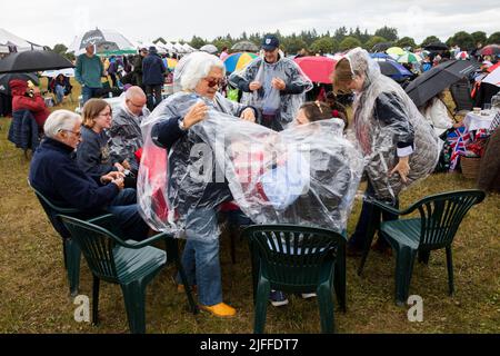Woodstock, Oxfordshire, Großbritannien. 2.. Juli 2022. Zwei Frauen ziehen einen Regenponcho an. Battle Prom Picknick-Konzerte. Blenheim Palace. Vereinigtes Königreich. Quelle: Alexander Caminada/Alamy Live News Stockfoto