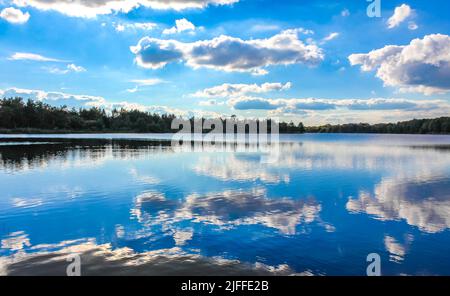 Norddeutsch Stoteler See blaues Wasser mit Wolkenspiegelung und Naturlandschaftspanorama im Stotel Loxstedt Cuxhaven Niedersachsen Deutschland. Stockfoto