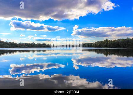 Norddeutsch Stoteler See blaues Wasser mit Wolkenspiegelung und Naturlandschaftspanorama im Stotel Loxstedt Cuxhaven Niedersachsen Deutschland. Stockfoto