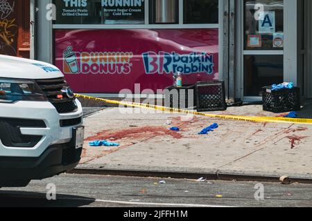 2. Juli 2022: Nach einer Schießerei vor Dunkin' Donuts in Manhattans Lower East Side, NY, bedeckt eine Spur von Blut und chirurgischen Handschuhen den Bürgersteig Stockfoto