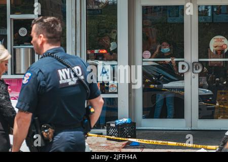 2. Juli 2022: Mitarbeiter von Dunkin' Donuts schauen aus dem Schaufenster, nachdem vor ihr in Manhattans Lower East Side, New York, ein Mann geschossen wurde Stockfoto