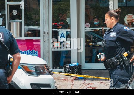 2. Juli 2022: Mitarbeiter von Dunkin' Donuts schauen aus dem Schaufenster, nachdem vor ihr in Manhattans Lower East Side, New York, ein Mann geschossen wurde Stockfoto