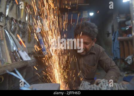 2. Juli 2022, Lahore, Punjab, Pakistan: Pakistanische Schmiede schärfen Fleischspalter verschiedene Werkzeuge und Messer, mit denen Tiere in ihrem Metallgeschäft vor dem muslimischen Fest von Eid al-Adha in Lahore geopfert werden können. Eid al-Adha, der wichtigste islamische Feiertag der muslime auf der ganzen Welt, wird „Eid ul-Adha“, auch bekannt als das Opferfest (Qurbani), feiern, um den islamischen Monat Zil Hijjah zu begehen. Er schlachtet Schafe, Ziegen, Kühe und Kamele, um der Bereitschaft des Propheten Abraham zu gedenken, seinen Sohn Ismail auf Gottes Befehl zu opfern. (Bild: © Rana Sajid Hussain/Pacific Press via Stockfoto