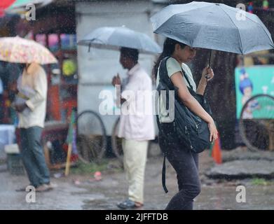 Pendler laufen bei starken Regenfällen in Agartala. Tripura, Indien. Stockfoto