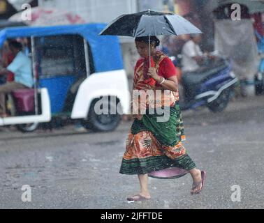 Pendler laufen bei starken Regenfällen in Agartala. Tripura, Indien. Stockfoto