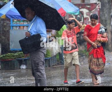 Pendler laufen bei starken Regenfällen in Agartala. Tripura, Indien. Stockfoto