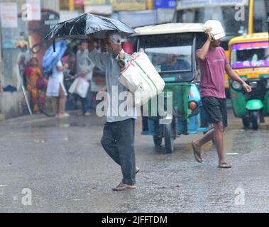 Pendler laufen bei starken Regenfällen in Agartala. Tripura, Indien. Stockfoto