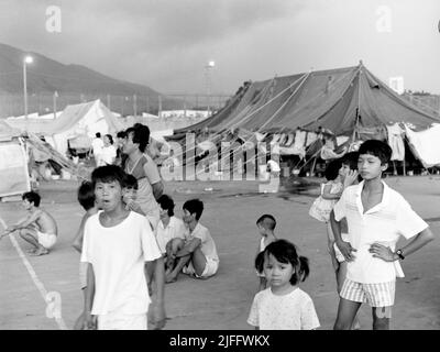 Das vietnamesische Untersuchungsgefängnis Shek Kong wurde 1989 in wenigen Wochen am westlichen Ende der Militärpiste in Shek Kong, New Territories, Hongkong, errichtet. Auf der Start- und Landebahn wurden Zelte aufgestellt, und das Gras auf beiden Seiten wurde von einem Metallzaun umgeben, der von Stacheldraht gekrönt wurde. Zehntausende vietnamesische Asylbewerber sind in den Jahren der Operation Photo, die im Dezember 1990 aufgenommen wurde, durch das Lager gegangen. Stockfoto