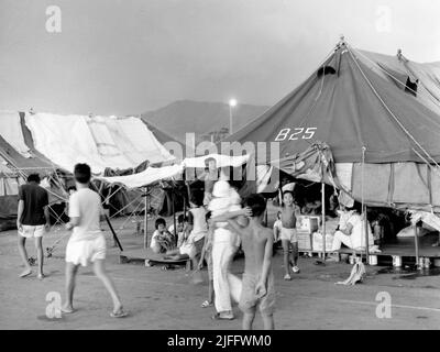 Das vietnamesische Untersuchungsgefängnis Shek Kong wurde 1989 in wenigen Wochen am westlichen Ende der Militärpiste in Shek Kong, New Territories, Hongkong, errichtet. Auf der Start- und Landebahn wurden Zelte aufgestellt, und das Gras auf beiden Seiten wurde von einem Metallzaun umgeben, der von Stacheldraht gekrönt wurde. Zehntausende vietnamesische Asylbewerber sind in den Jahren der Operation Photo, die im Dezember 1990 aufgenommen wurde, durch das Lager gegangen. Stockfoto