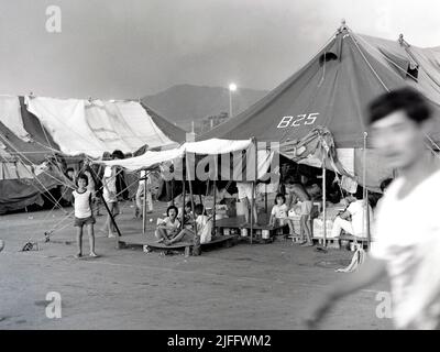 Das vietnamesische Untersuchungsgefängnis Shek Kong wurde 1989 in wenigen Wochen am westlichen Ende der Militärpiste in Shek Kong, New Territories, Hongkong, errichtet. Auf der Start- und Landebahn wurden Zelte aufgestellt, und das Gras auf beiden Seiten wurde von einem Metallzaun umgeben, der von Stacheldraht gekrönt wurde. Zehntausende vietnamesische Asylbewerber sind in den Jahren der Operation Photo, die im Dezember 1990 aufgenommen wurde, durch das Lager gegangen. Stockfoto