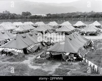 Das vietnamesische Untersuchungsgefängnis Shek Kong wurde 1989 in wenigen Wochen am westlichen Ende der Militärpiste in Shek Kong, New Territories, Hongkong, errichtet. Auf der Start- und Landebahn wurden Zelte aufgestellt, und das Gras auf beiden Seiten wurde von einem Metallzaun umgeben, der von Stacheldraht gekrönt wurde. Zehntausende vietnamesische Asylbewerber sind in den Jahren der Operation Photo, die im Dezember 1990 aufgenommen wurde, durch das Lager gegangen. Stockfoto