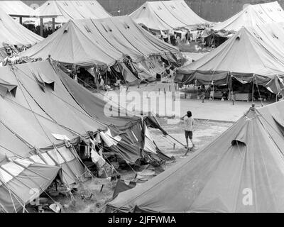 Das vietnamesische Untersuchungsgefängnis Shek Kong wurde 1989 in wenigen Wochen am westlichen Ende der Militärpiste in Shek Kong, New Territories, Hongkong, errichtet. Auf der Start- und Landebahn wurden Zelte aufgestellt, und das Gras auf beiden Seiten wurde von einem Metallzaun umgeben, der von Stacheldraht gekrönt wurde. Zehntausende vietnamesische Asylbewerber sind in den Jahren der Operation Photo, die im Dezember 1990 aufgenommen wurde, durch das Lager gegangen. Stockfoto