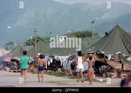 Das vietnamesische Untersuchungsgefängnis Shek Kong wurde 1989 in wenigen Wochen am westlichen Ende der Militärpiste in Shek Kong, New Territories, Hongkong, errichtet. Auf der Start- und Landebahn wurden Zelte aufgestellt, und das Gras auf beiden Seiten wurde von einem Metallzaun umgeben, der von Stacheldraht gekrönt wurde. Zehntausende vietnamesische Asylbewerber sind in den Jahren ihrer Operation durch das Lager gegangen. Foto aufgenommen im Dezember 1990. Stockfoto