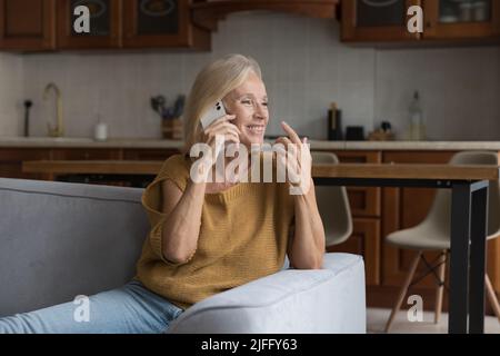 Ziemlich ältere Frau unterhalten sich gerne auf dem Handy Stockfoto