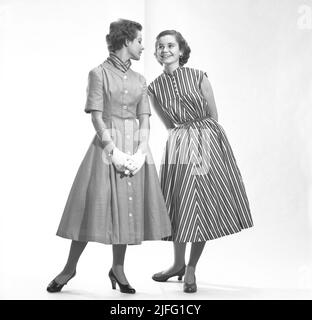 Zwei Mädchen im Teenageralter tragen 1953-jährige Mode-Kleider der schwedischen Designerin Margareta Westberg und ihrer Firma Tonnie-Modeler. Das erste Ready-Made-Bekleidungsunternehmen, das Mode für Jugendliche produzierte. Stockfoto