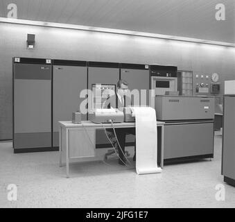 In der 1960s. Innenraum eines Raumes mit Computern und Menschen, die mit ihnen umgehen und Informationen registrieren und lesen. Der Mainframe-Computer ist ein IBM 360. IBM System 360 wurde häufig in der amerikanischen Fernsehserie Mad Men gesehen. Bild aufgenommen 1965 Kristoffersson Ref. DY125-6 Stockfoto