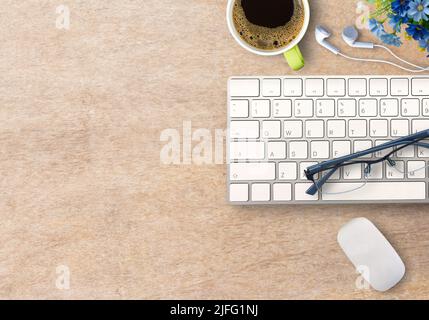 Draufsicht mit Mini-Tastatur und Maus mit Kaffee und Gläsern auf Holztisch. Geschäftskonzept Stockfoto