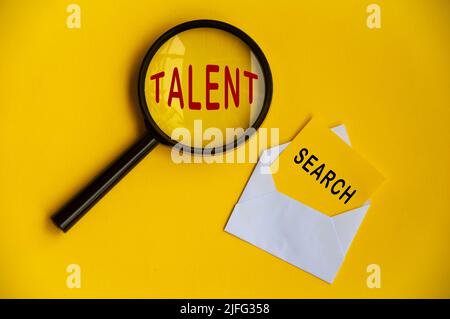 Talentsuche auf Lupe und gelbem Notizblock. Konzept für die Talentsuche Stockfoto
