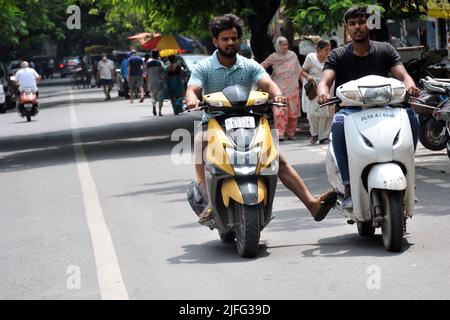 Neu Delhi, Neu Delhi, Indien. 3.. Juli 2022. Als der Scooty beschädigt wird, schiebt ihn ein weiterer Zweirad mit den Füßen und holt am Sonntag it.in East Delhi. (Bild: © Ravi Batra/ZUMA Press Wire) Stockfoto