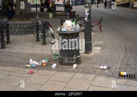 Über einem fliessenden Abfalleimer im Zentrum der Stadt mit Müll auf dem Bürgersteig herum Stockfoto