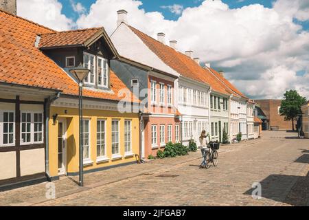 Schöne alte traditionelle Häuser in der Altstadt von Odense, Dänemark, Europa mit Mädchen mit Fahrrad Stockfoto