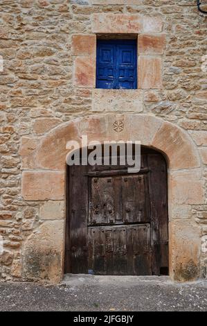 Steinfassade mit alter Holztür in Pesquera de Ebro, Burgos, Spanien, Europa Stockfoto