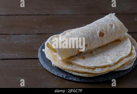 Tortillas auf Holztisch. Mexikanisches Brot Stockfoto