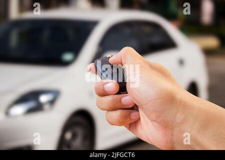 Männer Hand drückt auf der Fernbedienung Auto Alarmanlagen Stockfoto