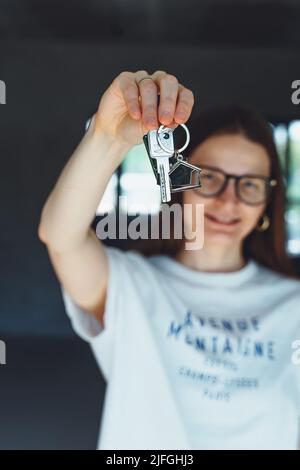 Glückliche Frau Mieter Käufer Umzug in neues Zuhause Nehmen Sie Selfie auf Handy-Kamera mit Schlüsseln in der Hand. Aufgeregt junge Millennial Mädchen stolz auf den Kauf Wohnung machen vi Stockfoto