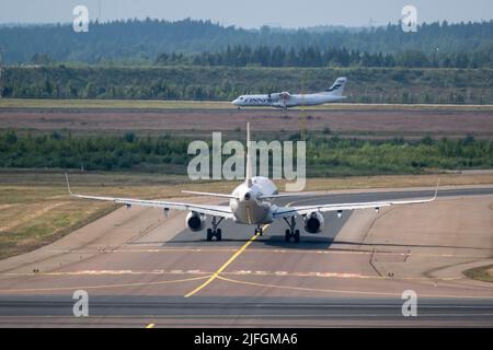 Helsinki / Finnland - 2. JULI 2022: Airbus A321, von Finnair betrieben, rollt am Flughafen Helsinki. Ein ATR-72, der im Hintergrund abbricht Stockfoto