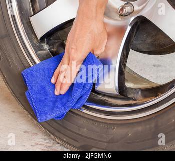 Hand mit Mikrofaser Tuch Reinigung Rad Auto. Stockfoto