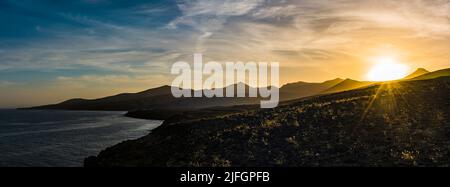 Sonnenuntergangspanorama über die Vulkanlandschaft bei Puerto Calero, Lanzarote, Spanien Stockfoto