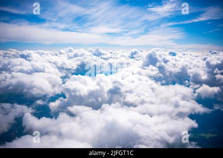 Luftaufnahme Szene der ländlichen Ort, die unter weißen flauschigen Wolken und blauen hellen Himmel Hintergrund versteckt. Stockfoto