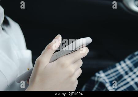 Nahaufnahme Frau Hand hält ein Handy in der Kabine. Stockfoto