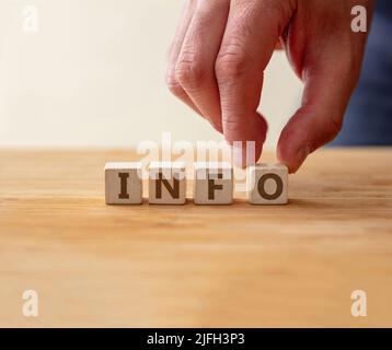 Info-Konzept. Wort-Info auf Holzwürfel mit Finger berührt Buchstabe o Informationen, empfohlene Nachricht für Unterstützung, Support, Lösung, Fragen und Antworten Stockfoto