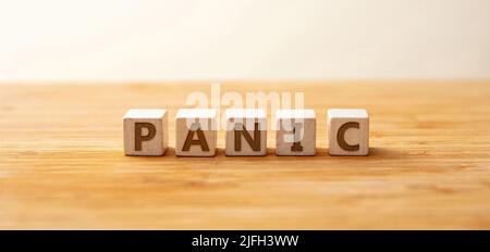 Panic Text auf Holzwürfel auf Holztisch Hintergrund. Plötzliche unkontrollierbare Angst oder Angst braucht eine psychische Gesundheitsversorgung. Metapher, Stress im Geschäft und Stockfoto