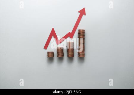 Konzept für steigende Inflation, Kosten und Preise, Stapel von Münzen in den Geschäftsdiagrammen mit Pfeil nach oben Stockfoto