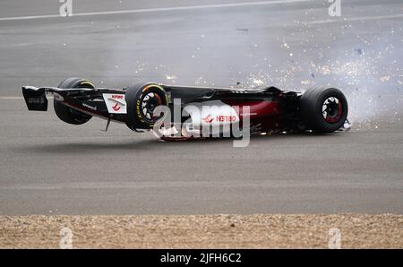 Zhou Guanyu von Alfa Romeo gleitet nach einer Kollision zu Beginn des Rennens während des Grand Prix von Großbritannien 2022 in Silverstone, Towcester, zur Barriere. Bilddatum: Sonntag, 3. Juli 2022. Stockfoto