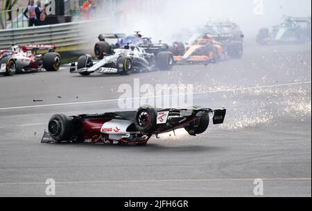 Zhou Guanyu von Alfa Romeo gleitet nach einer Kollision zu Beginn des Rennens während des Grand Prix von Großbritannien 2022 in Silverstone, Towcester, zur Barriere. Bilddatum: Sonntag, 3. Juli 2022. Stockfoto