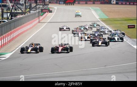 Red Bull's Max Verstappen (links) und Ferrari's Carlos Sainz kämpfen nach dem Neustart während des Grand Prix von Großbritannien 2022 in Silverstone, Towcester, in die erste Kurve. Bilddatum: Sonntag, 3. Juli 2022. Stockfoto