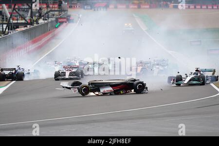 Zhou Guanyu von Alfa Romeo gleitet nach einer Kollision zu Beginn des Rennens während des Grand Prix von Großbritannien 2022 in Silverstone, Towcester, zur Barriere. Bilddatum: Sonntag, 3. Juli 2022. Stockfoto