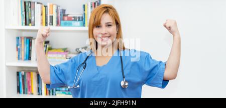 Jubelnde Rothaarige Krankenschwester bei der Arbeit in der Klinik Stockfoto