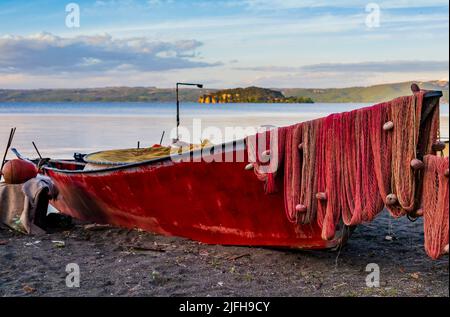 Ein typisches Fischerboot legte am Marta-Strand an, einem kleinen mittelalterlichen Dorf am Bolsena-See, Provinz Viterbo, Latium, Italien Stockfoto