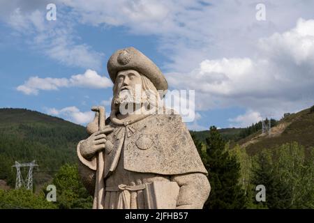 Statue von Santiago Peregrino (hl. Jakobus dem Großen als Pilger) mit dem üblichen Mantel, Jakobsmuscheln, Stab und Kürbis entlang des Camino Frances in Stockfoto