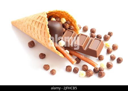 Eiswaffelkegel mit verschiedenen Schokoladenbonbons auf weißem Hintergrund isoliert. Stockfoto