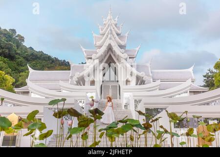 Reisende Frau in Kleid zu Fuß vor dem schönen weißen und silbernen Tempel im thai-Stil. Reisen und Urlaub Asia. Buddhistischer Tempel auf Phuket Stockfoto