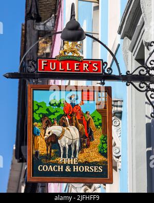 London, Großbritannien - 8.. März 2022: Das traditionelle hängende Pub-Schild an der Außenseite des öffentlichen Hauses Coach and Horses, das sich an der Greek Street in der Soh befindet Stockfoto