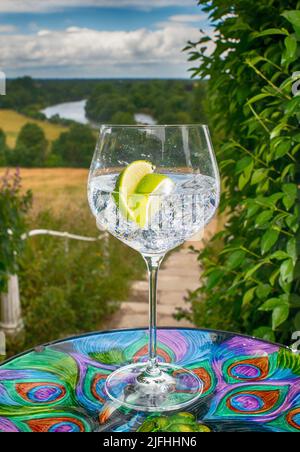 Gin-Glas mit Eiswürfeln und einer Scheibe Limette mit Blick auf die Brüstung von Richmond Hill zur Themse Stockfoto