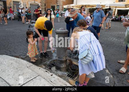 Rom, Italien, 3.. Juli 2022: Menschen, die Wasser aus einem Straßenspender auf dem Platz vor dem römischen Parthenon nahmen, als extreme Hitze von 37-39 Grad Celsius die Stadt afficierten.Quelle: Christian Creixell/Alamy Live News Stockfoto